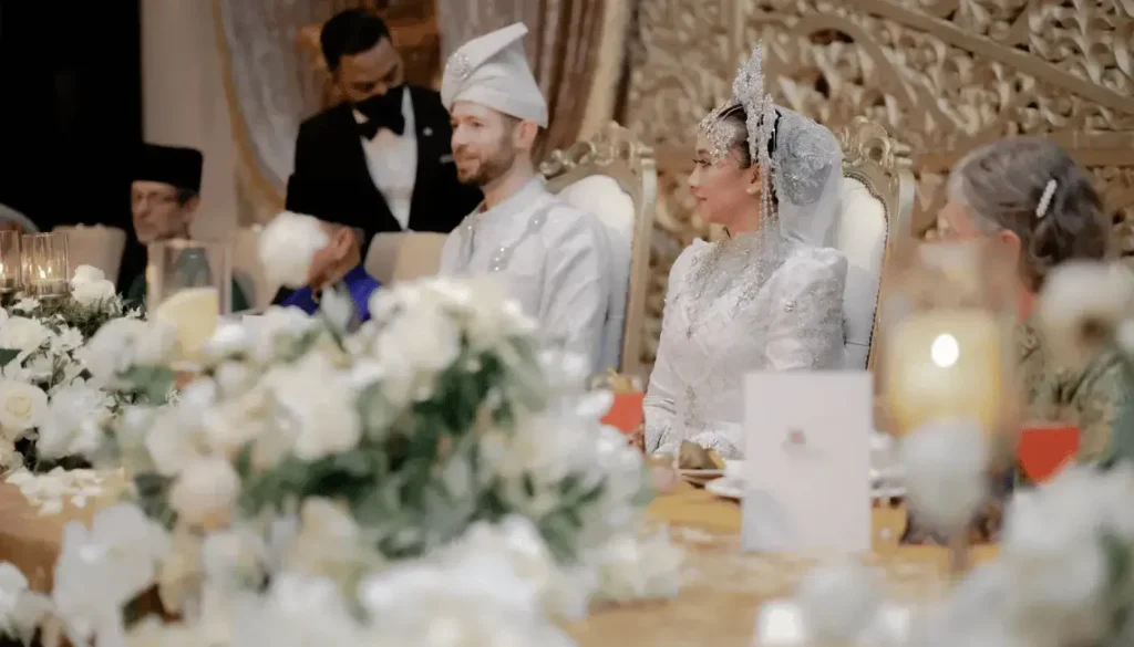 The bride and groom smiling on a beautifully decorated wedding dais.